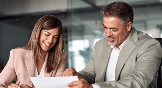 Two people looking at a piece of paper.